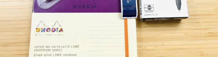 A purple soft cover Rhodia notebook, Midori 15 cm aluminium rule, Staedtler Night Blue 2 mm lead holder, 2 mm Staedtler Mars carbon leads and box of Pentel 1 mm EnerGel X pens.
